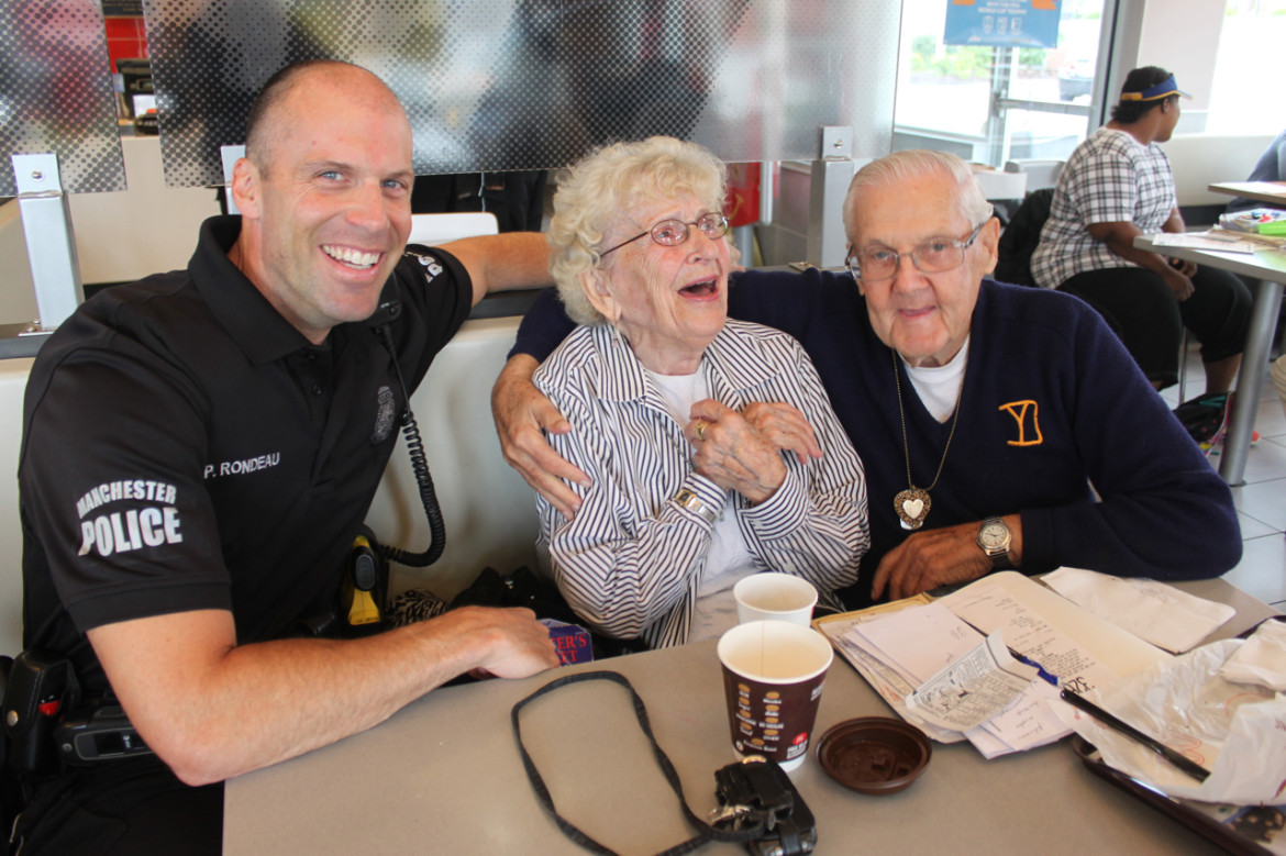 Manchester Police Officer Paul Rondeau shares coffee and a laugh with Marge Bienvenue and Howard McCarthy.