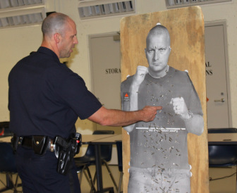 Officer Paul Rondeau talks about target practice using a cardboard "target man" cutout.