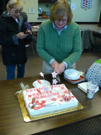 My Brother's Keeper founder Linda Heminway cuts the celebratory cake.