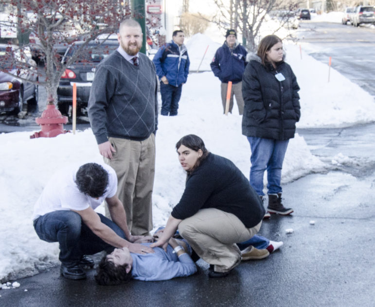 Bystanders assist someone who was pulled from a burning car on Jan. 29.