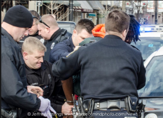 A police officer handcuffs Lovensky Jonick Maschabaz-Mesidor on Thursday.