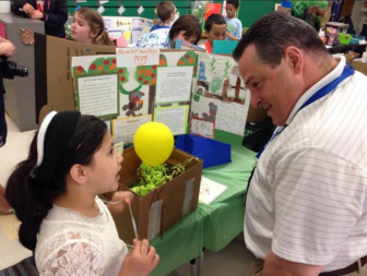 School board member John Avard talks with a student about the Gator Zoo.