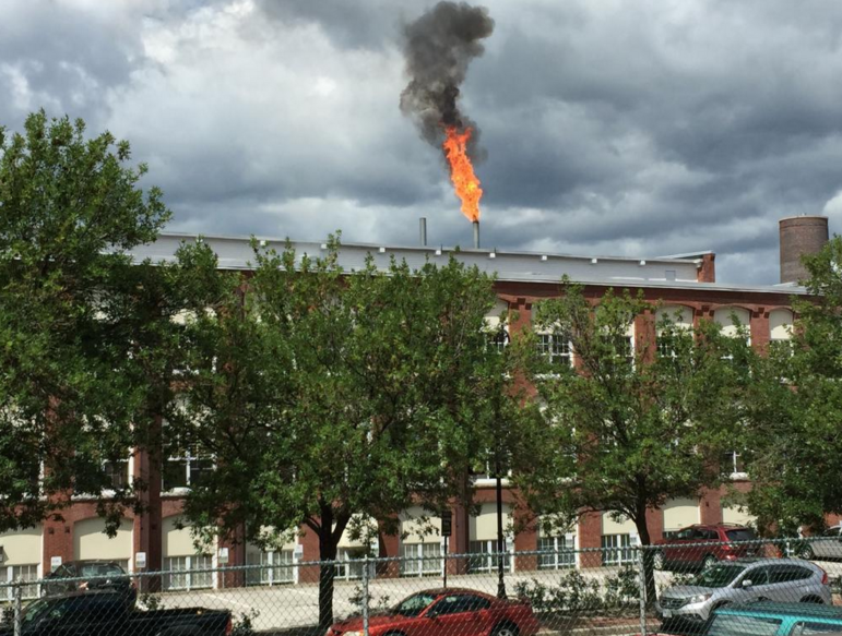 Fire shoots from the chimney at 540 Commercial Street. Image captured by Brian Mgrdichian, who works in a nearby mill building.