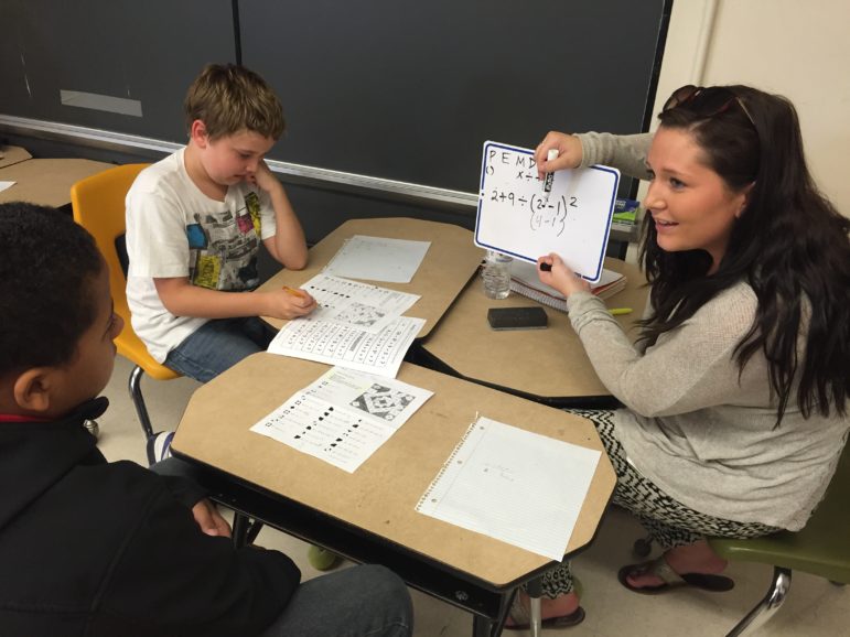 Hands on learning is a two-way street at Weston Elementary, as SNHU student Alivia Shea works with Andrew and Charles.