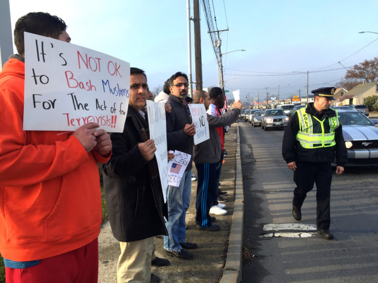 A police officer on detail walks next to members of an interfaith peace demonstration Dec. 11.