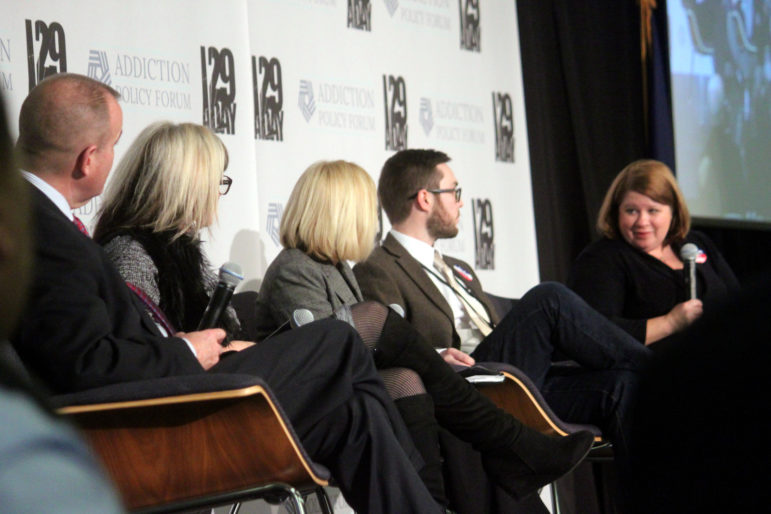 Holly Cekala, right, with microphone, speaks during a panel discussion on community response to the opioid crises, with fellow panelists, from left, Col. Robert Quinn, Kriss Blevens, moderator Tracy Caruso, and Dean LeMire.