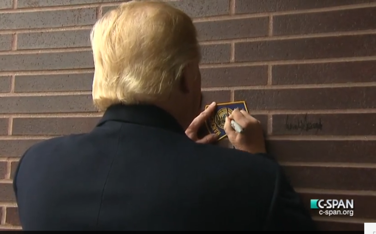 Trump autographed an MPD patch and also left his signature on the brick wall.