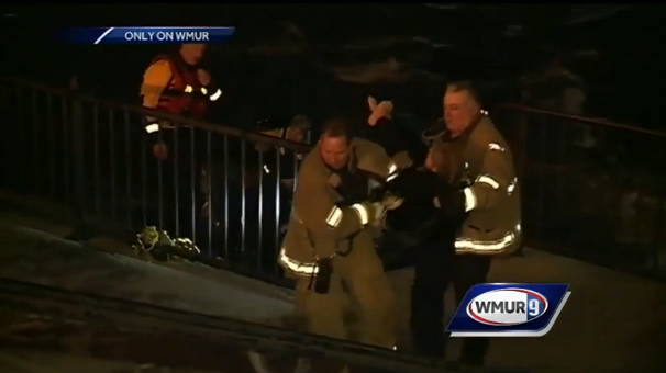 Firefighters carry woman rescued from the Merrimack up the steps at Arms Park late Friday night.