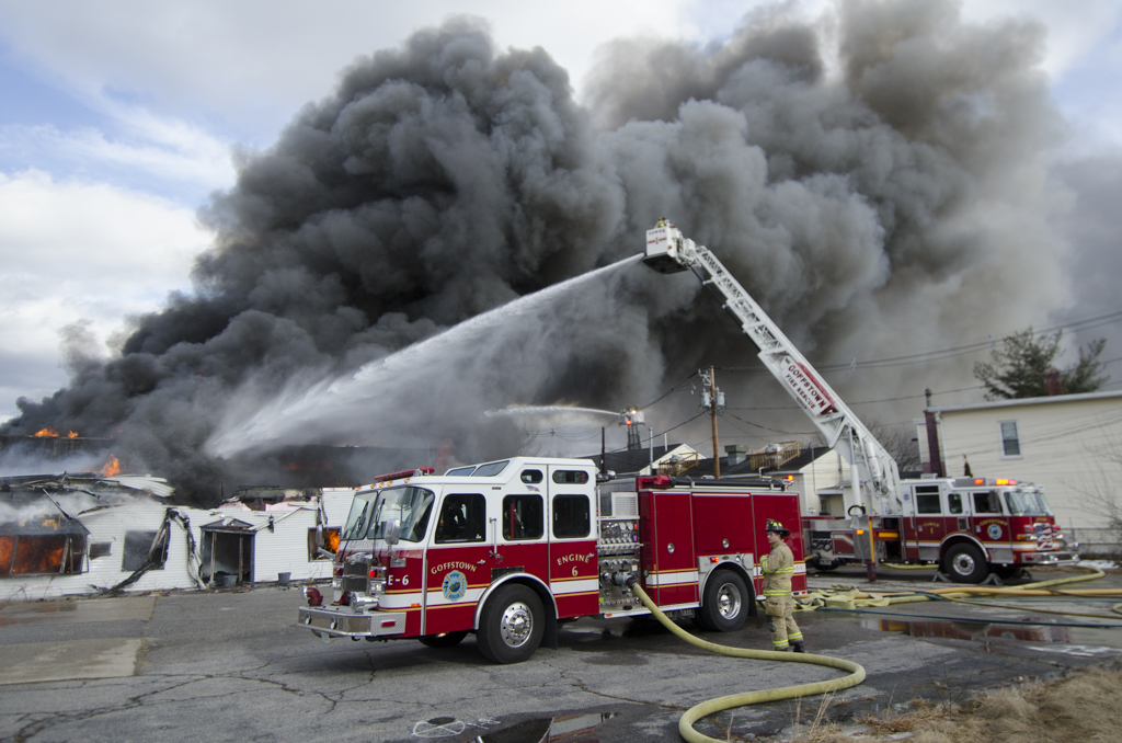 Thick black smoke rises from 711 Mast Road, the former Jutras Signs building.