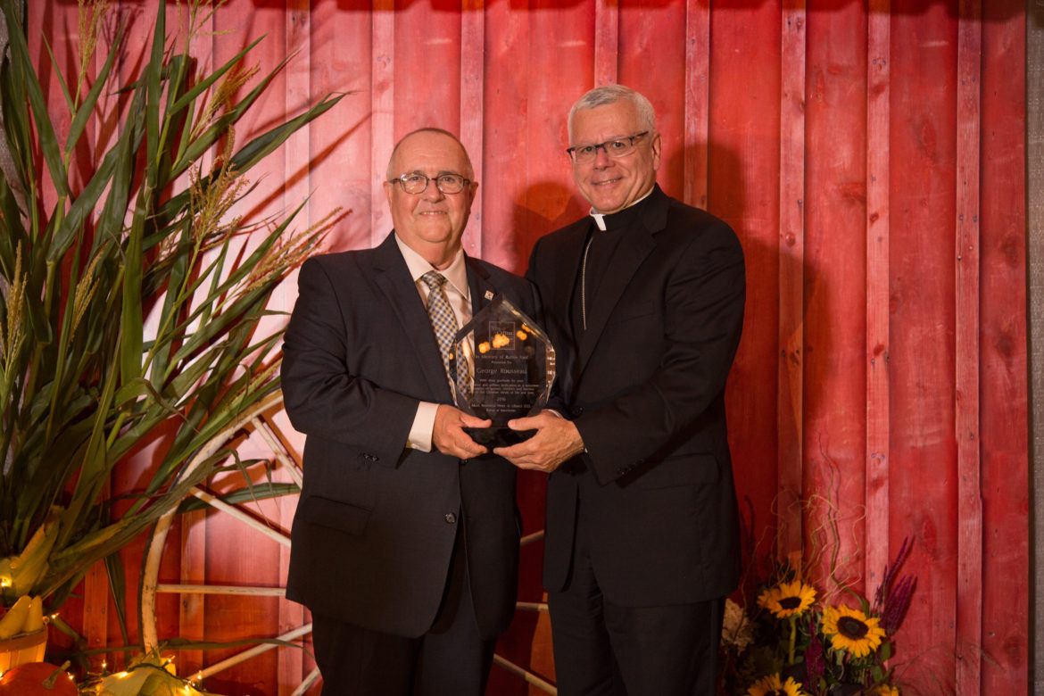 George Rousseau, left, of Manchester, accepts a volunteer of the year award from Bishop Libasci on behalf of his work as a CASA NH volunteer guardian ad litem.
