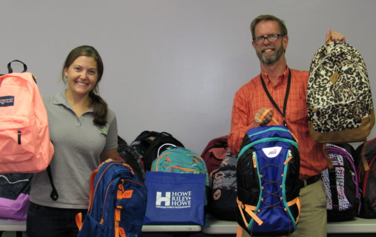 Child Health Services’ Becky Martin, left, and Rick Swanson receive23 backpacks full of school supplies from Howe, Riley & Howe in Manchester. Employees from the firm have supported this initiative, which provides the supplies to children in need, for the last three years.