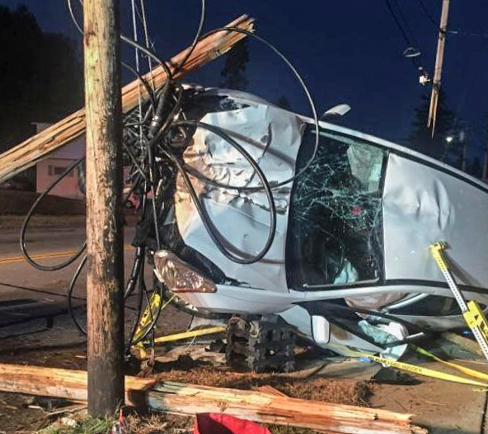 Impact from this crash severed the utility pole and left the car tangled up in the wires.