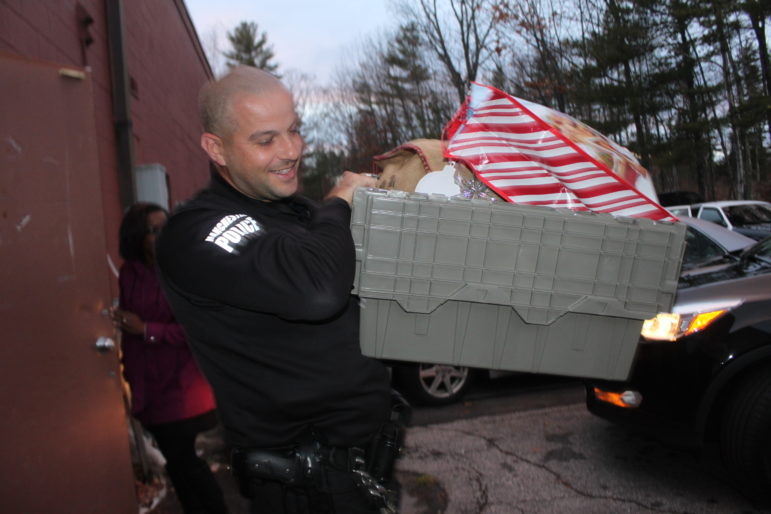Officer Brian Karoul carries an armload of goodies to his cruiser, ready for delivery.