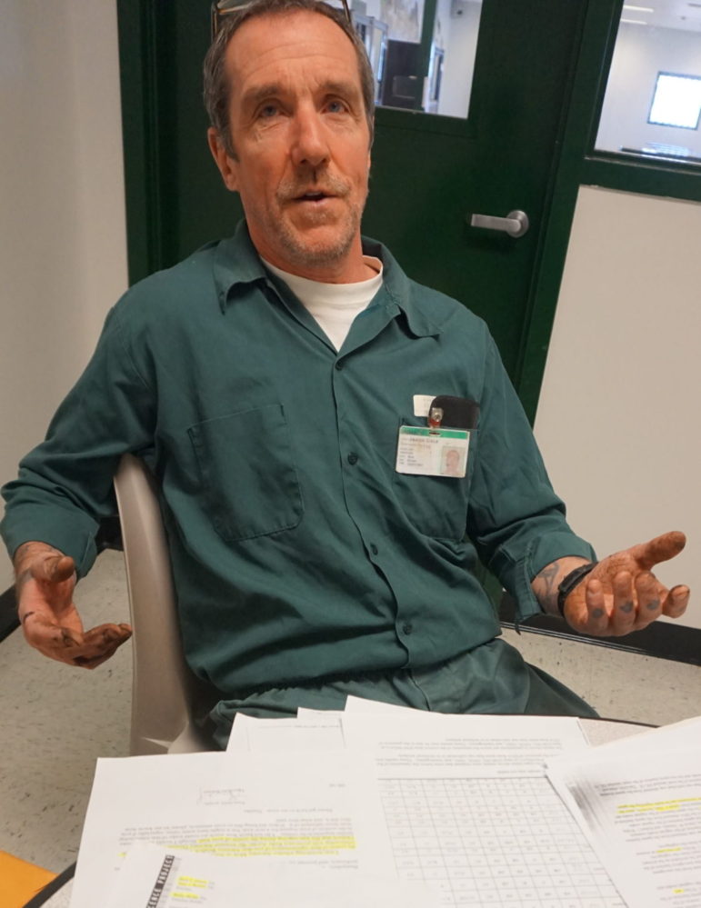 James Dale is pictured at the Northern New Hampshire Correctional Facility in Berlin with documents he has compiled in his appeal.