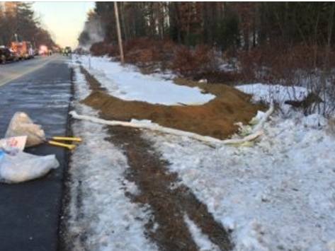 A "check dam" (earth berm and absorbant socks) were built by a NH DOT District 5 road crew to help contain up to 3,000 gallons of diesel fuel that spilled from a tractor trailer rollover. 