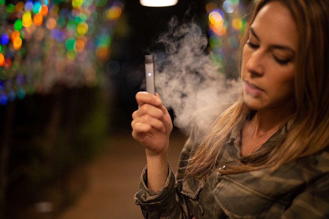 1080px Young girl holding her juul and vaping 44614233182