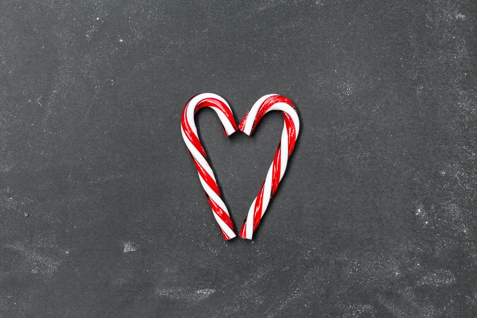 two red-and-white candy canes on gray surface