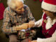 Female Caregiver and Male Senior with Christmas Gift